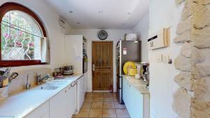 a kitchen with a sink and a refrigerator at Magnifique villa La Fenière En Provence in Aubagne +23 photos