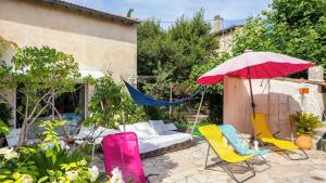 a patio with chairs and an umbrella and a couch at Magnifique villa La Fenière En Provence in Aubagne