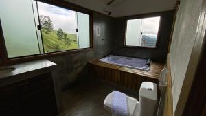 a bathroom with a tub and a toilet and a sink at Pousada Verde Serena SFX in São Francisco Xavier +56 photos