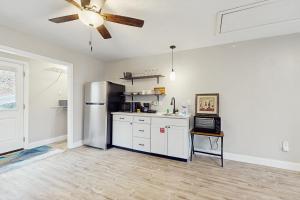 Una cocina con gabinetes blancos y un refrigerador de acero inoxidable. en Cozy Corner, en Caryville