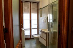 een badkamer met toilet en glazen douche bij Il Carrubo in Alghero