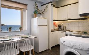 a kitchen with a white refrigerator and a window at Kalokairi Apartment in Agios Nikolaos