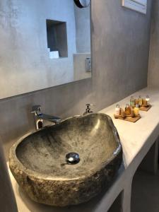 a stone sink in a bathroom with a mirror at Luxury apartment in the heart of Mykonos town in Mýkonos City