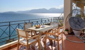 a table and chairs on a balcony overlooking the water at Kalokairi Apartment in Agios Nikolaos