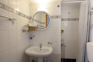a white bathroom with a sink and a mirror at Kalokairi Apartment in Agios Nikolaos
