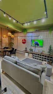 圣罗克São Hostel的客厅里有一张沙发，墙上有一台电视