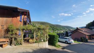 a white car parked in front of a building at Kuckucksnest - Ferienwohnung mit Traumblick im Schwarzwald in Bad Wildbad