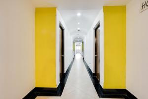 a hallway with yellow walls and black and white floors at Townhouse Margao Near Railway Station Formerly Hotel Tanish in Goa