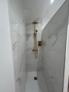 een badkamer met douche en witte marmeren muren bij Casa Peñas 2 in Ronda +27 foto's