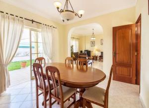een eetkamer met een houten tafel en stoelen bij Casa Camarinha in Carvoeiro