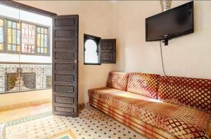 un salon avec un canapé et une télévision à écran plat dans l'établissement Riad Zitoune, à Marrakech