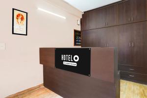 a room with a counter and wooden cabinets at Super Hotel O GMS Road Ballupur Chowk in Dehradun