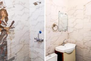 a bathroom with a sink and a mural on the wall at Super Hotel O GMS Road Ballupur Chowk in Dehradun