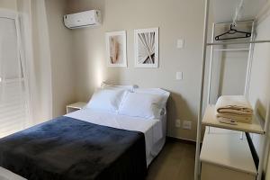 een kleine slaapkamer met een bed en een nachtkastje bij Apto 2 qtos com wi-fi e garagem in Londrina