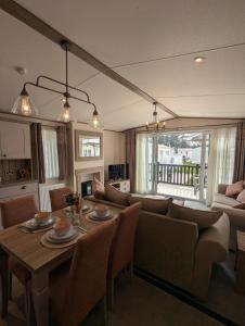 a living room with a table and a couch at PRESTIGIOUS BEAUTIFUL AND VERY SPACIOUS AMBLESIDE on AWARD WINNING SHOREFIELD COUNTRY PARK Entertainment Passes Included ST in Milford on Sea +21 photos
