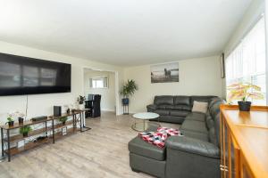 a living room with a couch and a flat screen tv at 65 - 5BR Randolph - Elegant Haven near Dog Park in Randolph