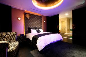 1 dormitorio con 1 cama grande y baño en Melody Motel en Keelung