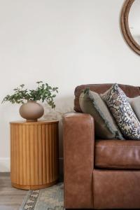 a brown leather couch with a plant on a table at Down Town Condo with gym pool BBQ jacuzzi in San Diego