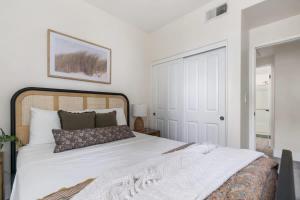 a bedroom with a large white bed and a door at Down Town Condo with gym pool BBQ jacuzzi in San Diego