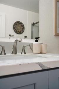 a bathroom counter with a sink and a mirror at Down Town Condo with gym pool BBQ jacuzzi in San Diego