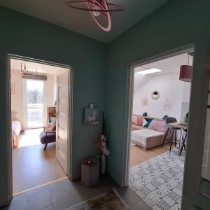 Una sala de estar con paredes verdes y un dormitorio. en Apartament Pastelowy, en Cracovia