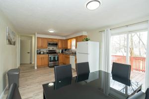 a kitchen with wooden cabinets and a white refrigerator at 65 - 5BR Randolph - Elegant Haven near Dog Park in Randolph