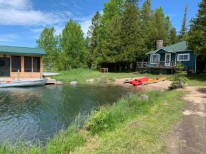 a house and a boat on the water next to a house at The Westender in Hessel