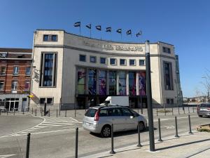um carro estacionado em frente a um edifício com bandeiras em chambre double em Charleroi