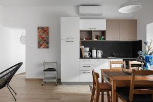 a kitchen and dining room with white cabinets and a table at Apartment Miha in Loborika
