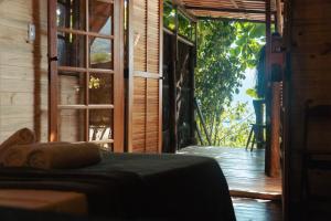 a bedroom with a bed and a door to a porch at MAMBEMBE hostel - Ilha Grande, Vila do Abraão in Abraão +71 photos