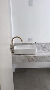 a white sink on a counter in a bathroom at Conforto e Localização Estratégica - Perto de Tudo in Joinville