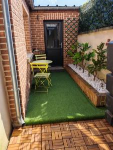 a small patio with a table and chairs on grass at Location d'appartements - Cosysejour - Calme Fibre Netflix in Amiens +29 photos