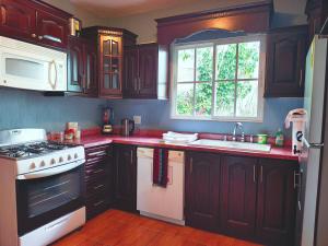 a kitchen with black cabinets and a white stove top oven at EstanciA in Esquipulas