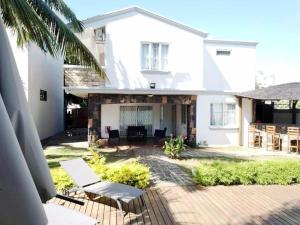 a white house with a patio and chairs at Villa Chanel avec piscine proche de la plage in Grand-Baie