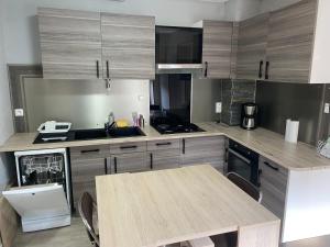 a kitchen with a wooden table and a counter top at La KB in Bruyères