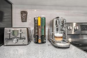 een aanrecht met een koffiezetapparaat en een blender bij 2 BR ground-level suite in a bungalow with full kitchen, parking, and 20 mins to Downtown in Toronto