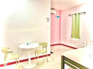 a room with a table and chairs and a bed at ธารารักเลย ภูกระดึง in Ban Huai Som