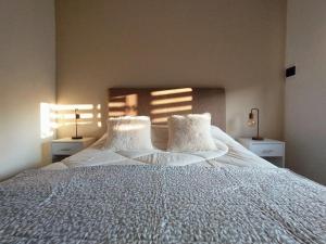 a bedroom with a large white bed with two pillows at La Merced Areco Cabañas in San Antonio de Areco +15 photos