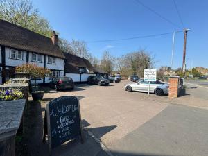 a sign in a parking lot next to a building at OYO The Greyhound Inn in Gerrards Cross