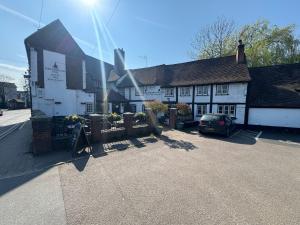a building with a car parked in front of it at OYO The Greyhound Inn in Gerrards Cross