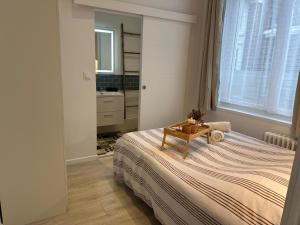 a bedroom with a bed with a table on it at Appart Cosy avec Terrasse - Ideal Couple - Zen - LeRelaisdOdile41 in Valenciennes