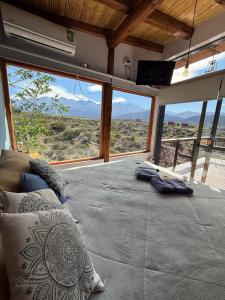 a bedroom with a bed with a view of the desert at Revolucionarte.Potrerillos in Potrerillos
