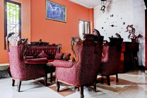 a living room with red chairs and a table at OYO 90268 Aliyah Syariah in Jakarta