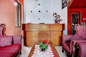 a living room with two red chairs and a table at OYO 90268 Aliyah Syariah in Jakarta