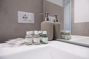 a bathroom counter with bottles of soap and a mirror at La Rocca Terrazza in Darfo +29 photos