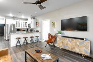 a living room with a tv on a wall at Hip Gruene Condo, Walk to Gruene Hall, On River! in New Braunfels
