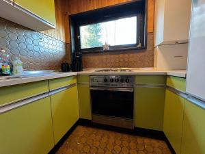 a kitchen with yellow cabinets and a black oven at Chalet BERGliebe Willingen- Nähe Skywalk in Willingen +8 photos