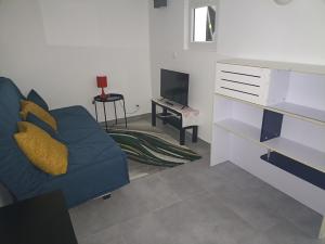 ein Wohnzimmer mit einem blauen Sofa und einem Fernseher in der Unterkunft Le Bon Repos - Séjours professionnels et vacances en famille aux portes de Paris in Garches + 74 Fotos