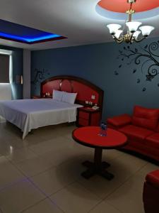 a bedroom with a bed and a table and a couch at Hospedaje El Suspiro in El Faisán +15 photos