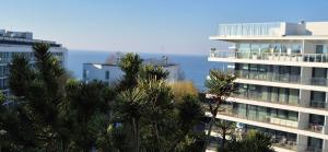 Blick auf ein Gebäude mit Bäumen davor in der Unterkunft Olympic Park C 606 Apartament z ogrodem na dachu in Kołobrzeg